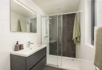 Moderne badkamer met douche en spiegel in Cannenburch, Veluwepark de Bosgraaf, Nederland.