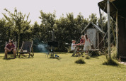 Familie nyder en solrig dag med picnic og afslapning på Feather Down Boerderij Ameland, Friesland, Holland.