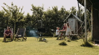 Familie genießt einen Tag im Grünen im Feather Down Boerderij Ameland Ferienpark, Friesland, Niederlande.