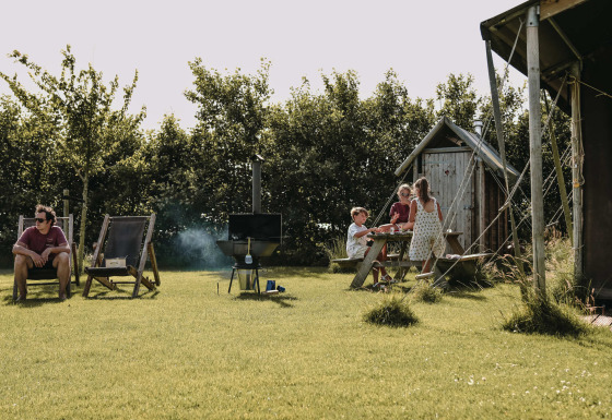Familie nyder en solrig dag med picnic og afslapning på Feather Down Boerderij Ameland, Friesland, Holland.