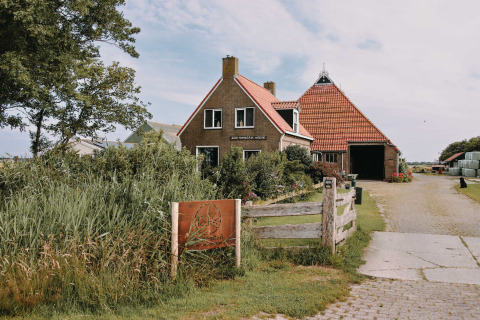Feather Down Boerderij Ameland parque vacacional en Frisia, Países Bajos, con una granja y jardín tradicional.
