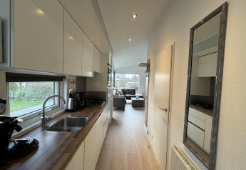 Cucina moderna nella cabina Velthorst a EuroParcs Parc du Soleil, Paesi Bassi, con vista sul soggiorno.