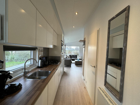 Cocina moderna de la cabaña Velthorst en EuroParcs Parc du Soleil, Países Bajos, con vista hacia la sala.