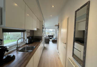 Cocina moderna de la cabaña Velthorst en EuroParcs Parc du Soleil, Países Bajos, con vista hacia la sala.