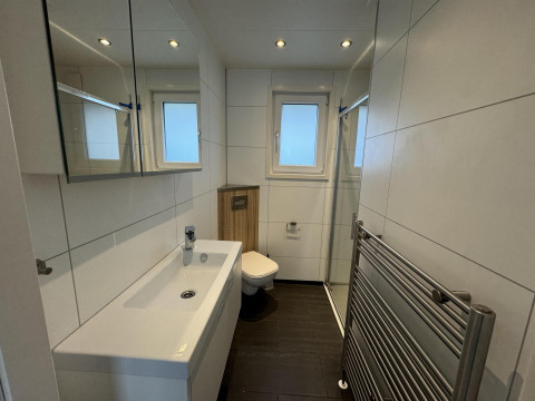 Baño moderno en la cabaña Velthorst de EuroParcs Parc du Soleil, Países Bajos, con ventana y ducha.