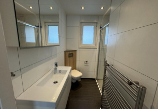 Modernes Bad in der Velthorst-Hütte im EuroParcs Parc du Soleil, Niederlande, mit Fenster und Dusche.