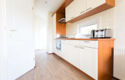 Cocina moderna en la cabaña Berkel de EuroParcs Parc du Soleil, Países Bajos, con gabinetes blancos.