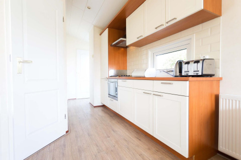 Cocina moderna en la cabaña Berkel de EuroParcs Parc du Soleil, Países Bajos, con gabinetes blancos.