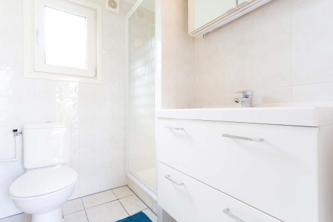 Helles Badezimmer mit WC, Dusche und weißen Möbeln in einer Berkel-Hütte im EuroParcs Parc du Soleil.