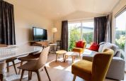 Salón luminoso en una cabaña Berkel en EuroParcs Parc du Soleil, con grandes ventanales y decoración moderna.
