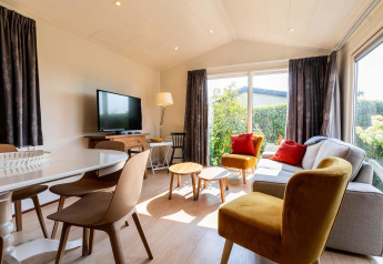 Lichte en gezellige woonkamer in een Berkel-hut bij EuroParcs Parc du Soleil met grote ramen en moderne stijl.