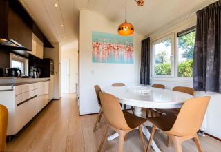 Cocina y comedor moderno en la cabaña Berkel de EuroParcs Parc du Soleil, Países Bajos, muy iluminados.