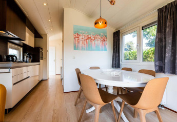 Cocina y comedor moderno en la cabaña Berkel de EuroParcs Parc du Soleil, Países Bajos, muy iluminados.