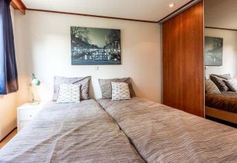 Slaapkamer in de Berkel-cabine bij EuroParcs Parc du Soleil, Nederland, met twee eenpersoonsbedden en moderne stijl.