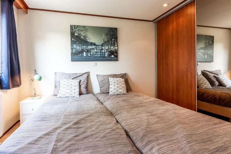 Dormitorio en la cabaña Berkel en EuroParcs Parc du Soleil, Países Bajos, con dos camas individuales y decoración moderna.