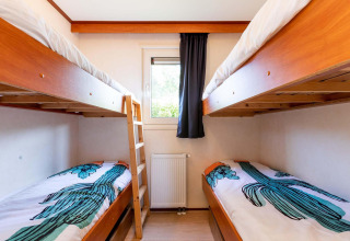 Chambre lumineuse avec deux lits superposés en bois à la cabane Berkel d’EuroParcs Parc du Soleil, Pays-Bas.