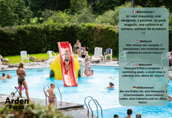 Udendørs swimmingpoolområde med vandrutsjebane, børn der leger og træer i baggrunden ved glamping.