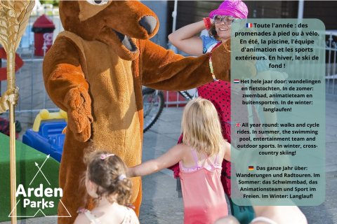 Bambini giocano con una mascotte e un adulto in un glamping; cartello Arden Parks in primo piano.