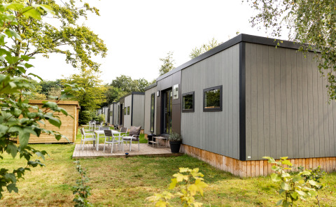 Buitenaanzicht van Taos XL Delux Mobile home lodge bij Baalse Hei in België, omgeven door natuur.