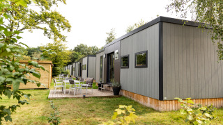 Outdoor view of the Taos XL Delux Mobile home lodge at Baalse Hei in Belgium, surrounded by greenery.