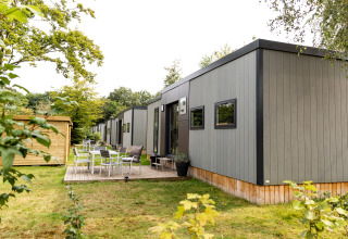 Außenaufnahme des Taos XL Delux Mobile Home-Lodge bei Baalse Hei in Belgien, umgeben von Grün.