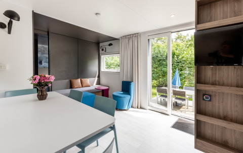 Licht, modern Taos XL Delux chalet in Baalse Hei, België, met terrasdeuren en zicht op de tuin.