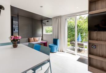 Licht, modern Taos XL Delux chalet in Baalse Hei, België, met terrasdeuren en zicht op de tuin.