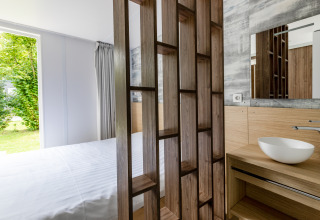 Moderne Taos XL Delux mobiele lodge aan Baalse Hei in België met zicht op slaapkamer en badkamer.