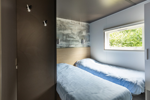 Moderne Taos XL Delux stacaravan bij Baalse Hei in België met twee eenpersoonsbedden en groot raam.