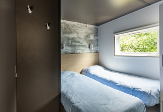 Moderne Taos XL Delux stacaravan bij Baalse Hei in België met twee eenpersoonsbedden en groot raam.