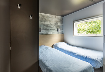 Moderne Taos XL Delux stacaravan bij Baalse Hei in België met twee eenpersoonsbedden en groot raam.