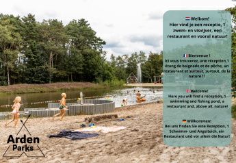 Niños juegan en una playa de arena junto a un estanque, camping de lujo rodeado de naturaleza, Arden Parks.