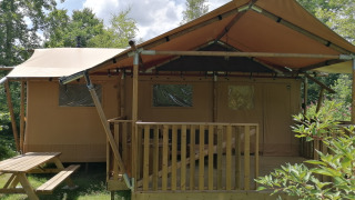 Safari tent Dreamer at Baalse Hei, Belgium, featuring a wooden terrace and bench in green nature.
