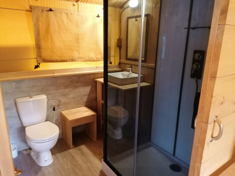 Bathroom inside Safari tent Dreamer at Baalse Hei, Belgium, showing toilet, sink, and shower cabin.
