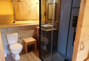 Bathroom inside Safari tent Dreamer at Baalse Hei, Belgium, showing toilet, sink, and shower cabin.