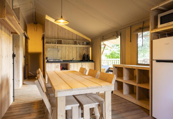 Tenda safari Dreamer a Baalse Hei in Belgio, sala da pranzo, arredi in legno e cucina compatta.