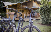 Dos bicicletas aparcadas frente a una tienda safari Ranger Lodge en el camping Baalse Hei en Bélgica.