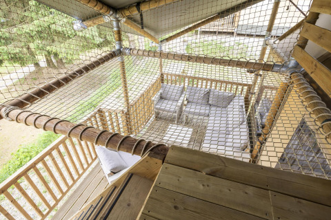 View from a safari tent at Ranger Lodge, Baalse Hei, Belgium, featuring net flooring and outdoor seating.