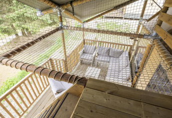 Uitzicht vanuit een safaritent Ranger Lodge, Baalse Hei, België, met netvloer en loungehoek buiten.