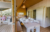 Indvendig og udvendig udsigt over en Ranger Lodge safari telt på Baalse Hei, Belgien, med spise- og loungeområde.