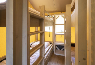 Foto interior de la tienda safari Ranger Lodge en Baalse Hei, Bélgica, con literas de madera.