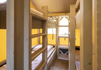 Indvendig billede af Ranger Lodge safari-teltet på Baalse Hei i Belgien med køjesenge og træinteriør.