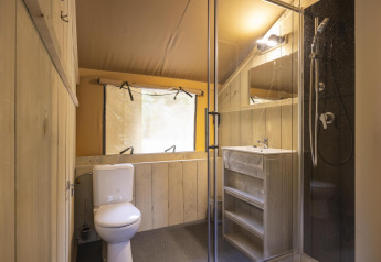 Badeværelse i Ranger Lodge safari-telt på Baalse Hei i Belgien med bruser, toilet og vask.
