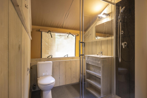 Bathroom inside Ranger Lodge safari tent at Baalse Hei in Belgium, featuring shower, toilet and sink.