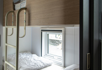 Modern stapelbed met houten panelen en raam in een Taos XL lodge bij Petite Suisse, België.