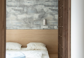 Dormitorio moderno en la cabaña Taos XL en Petite Suisse, Bélgica, con cama doble y pared decorativa.