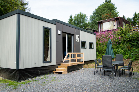 Moderne Taos XL-lodge op Petite Suisse in België, met een buitenterras en groene, natuurlijke omgeving.