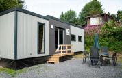 Moderne lodge Taos XL bij Petite Suisse in België, met buiteneethoek en groene natuuromgeving.