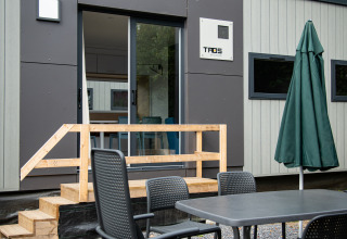 Zona de comedor exterior frente a una cabaña Taos XL moderna en Petite Suisse, Bélgica.