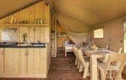 Indendørs billede af lodge Sunshine på Petite Suisse med træmøbler, køkken og spisebord i Belgien.